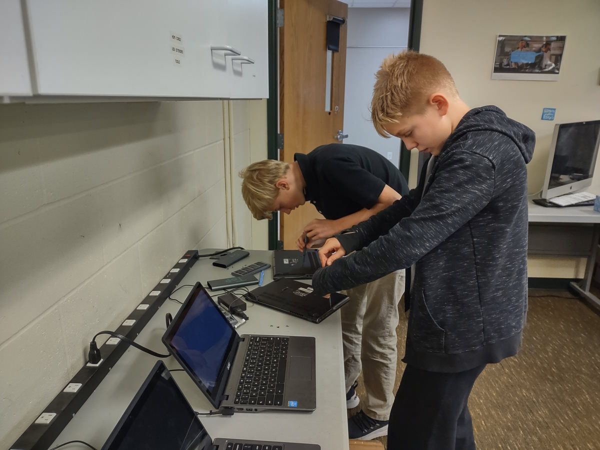 students fixing laptop