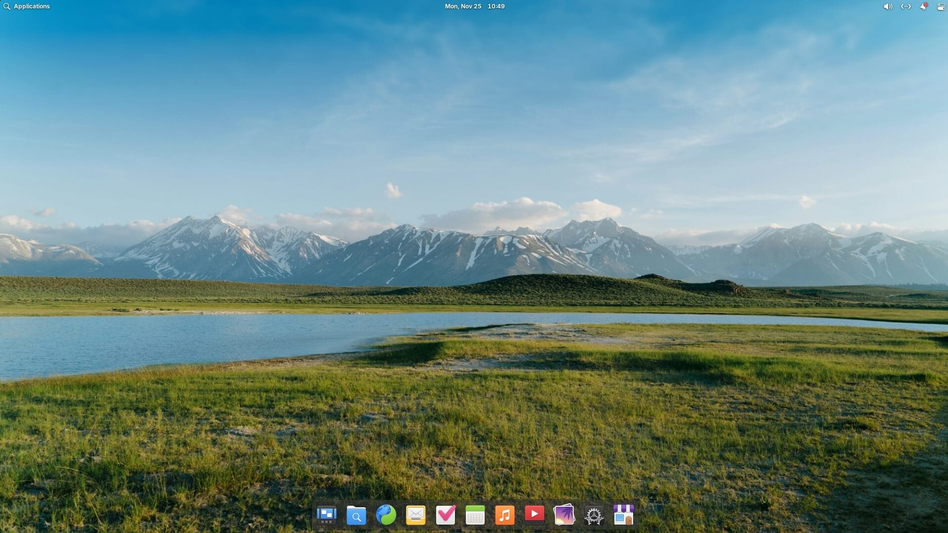 elementary os 8 homescreen with the new wallpaper featuring a greenland with mountains and a lake