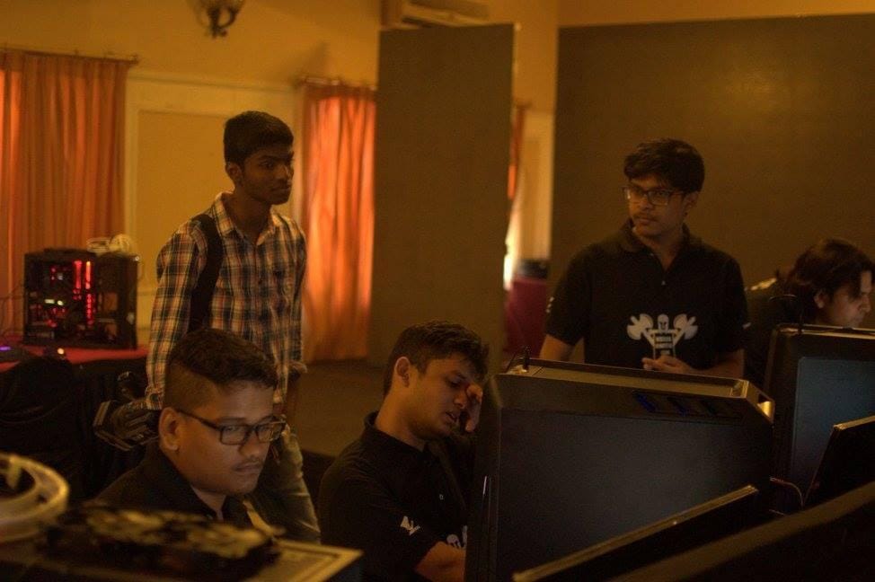 a photo that shows five people working on computers, some of them are fed up