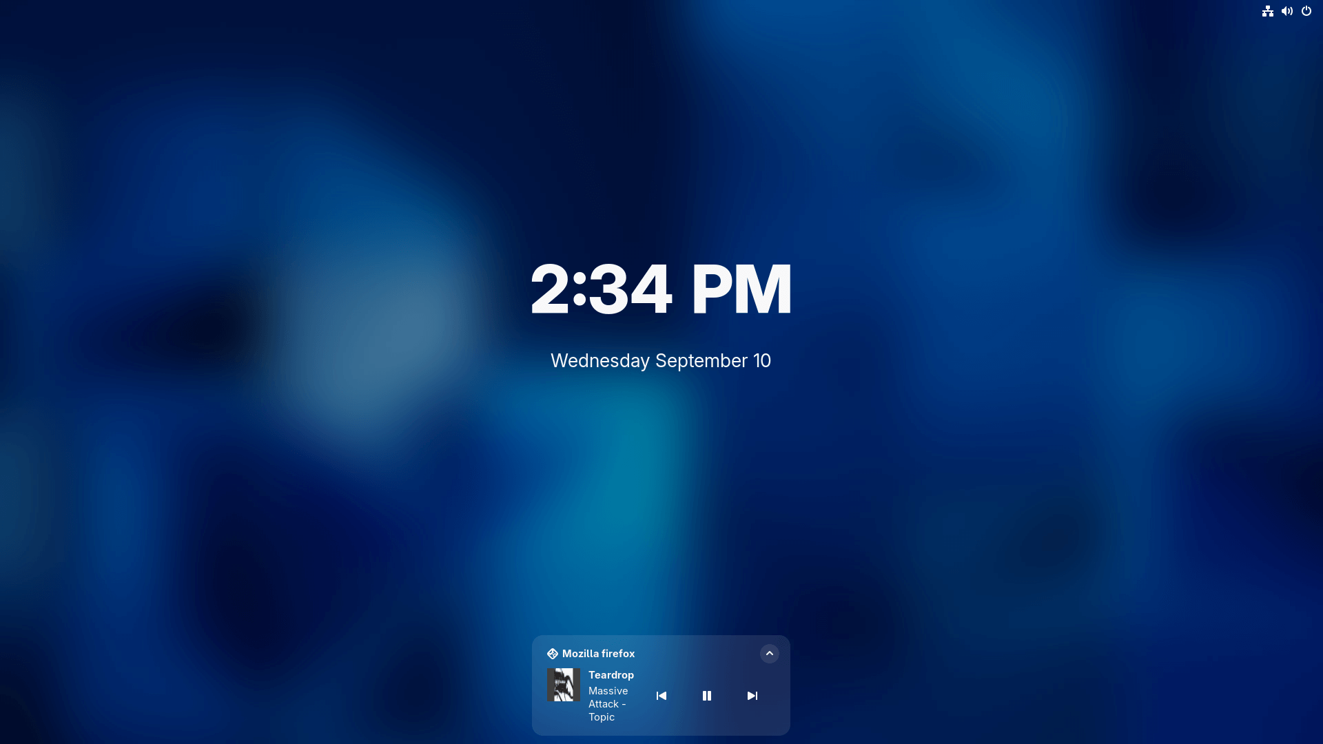 teardrop by massive attack is shown playing in the new media controls on gnome 49's lock screen, the time and date are shown above it too