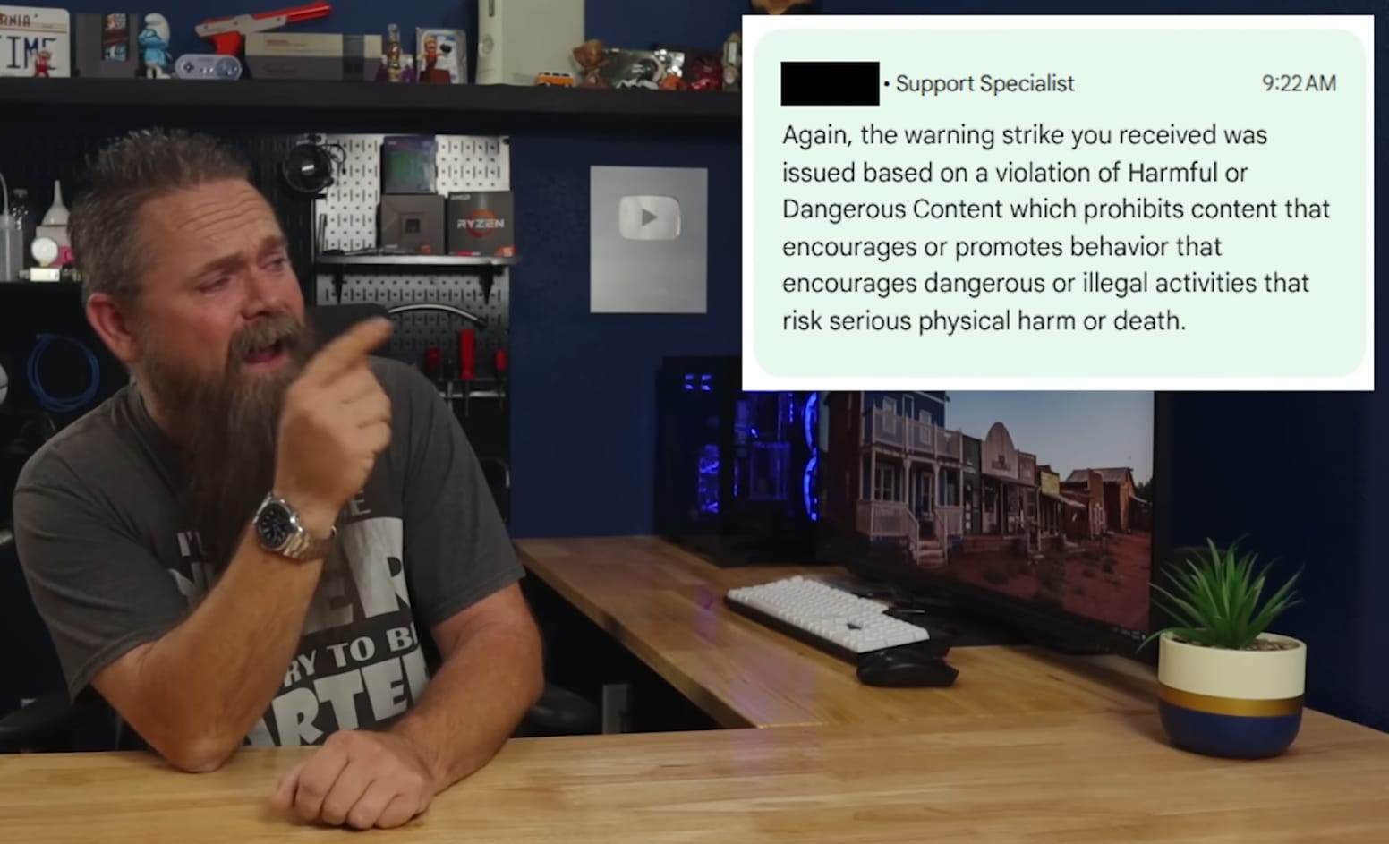 a bearded man (the host of cybercpu tech) is sat on a desk on the left, pointing at youtube's reasoning behind the strike on his channel